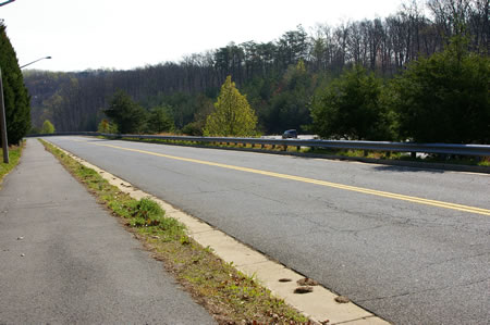 The trail descends a grade as it parallels Hunter Village Dr. and the Franconia - Springfiled Parkway.