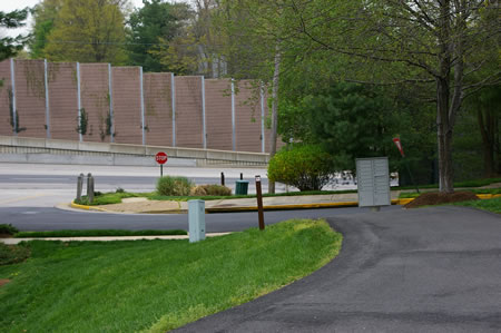 The trail crosses a second appearance of Stream Way. Turn left on the sidewalk on the other side to walk a short distance to the Fairfax County Parkway.