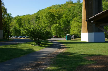 Follow the trail under the railroad bridge into the parking lot.