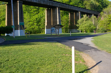 Turn left at the intersecting trail from the parking lot and follow it under the railroad bridge.