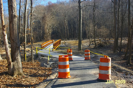 The trail passes through a construction area and crosses a bridge over Accotink Creek.