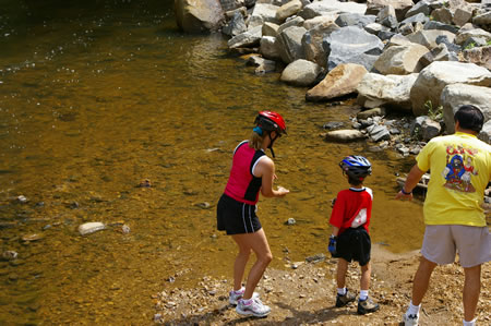 This family is having fun skipping stones in the creek.