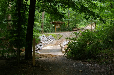 The trail crosses the side creek on columns.