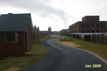 The trail passes between the former prison wall and the gated community.