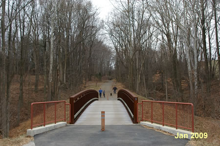 The trail crosses a bridge over Giles Run and goes up a hill.