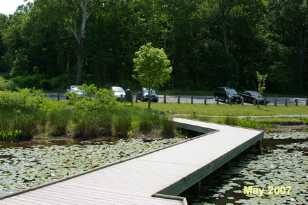 Cross the bridge over the pond to return to the parking area and conclude the walk.