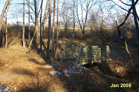 The trail passes over a small side stream on a bridge.