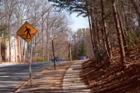 The trail turns right to follow the sidewalk along Colts Neck Rd.
