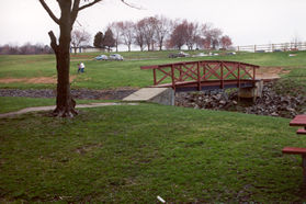 Turn right to cross the bridge shown, then left along the grass paralleling the stream.