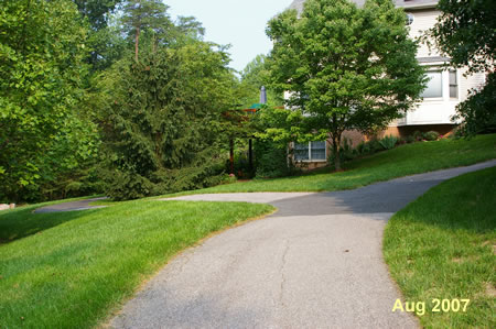 A trail intersects from the houses on the right.  Turn left to continue around the lake.
