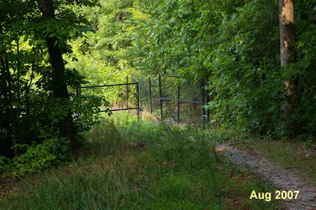 The trail passes through a gate in a fence after a short distance.