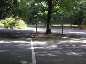 The trail follows the edge of the parking lot and turns right prior to the tennis courts.
