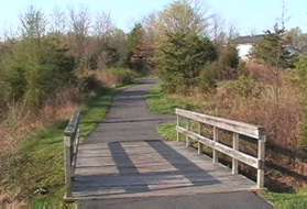 After crossing the first bridge a path intersects from the right.  Stay straight on the current path.