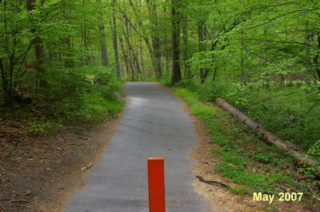 The trail passes a vehicle barrier and goes down to Rocky Run.