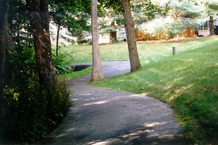 The trail climbs a steep hill with homes on both sides.